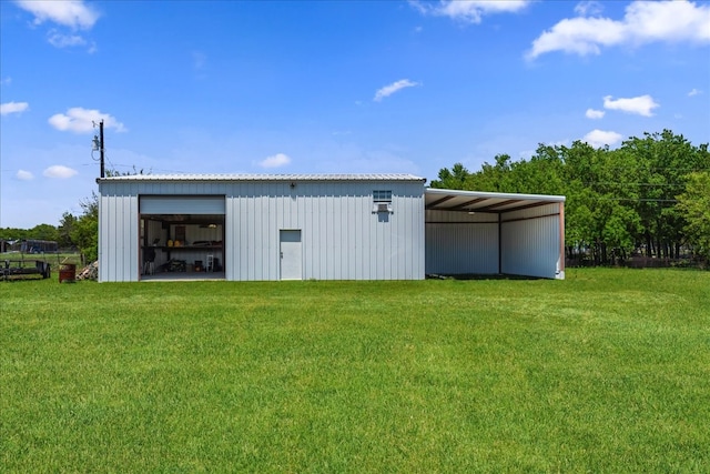 view of outdoor structure with a carport and a lawn