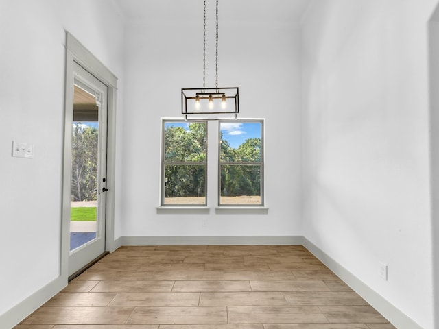 unfurnished dining area featuring light hardwood / wood-style floors and a notable chandelier