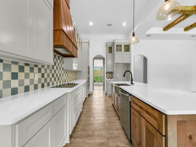 kitchen featuring white cabinets, pendant lighting, light hardwood / wood-style flooring, a center island with sink, and beam ceiling