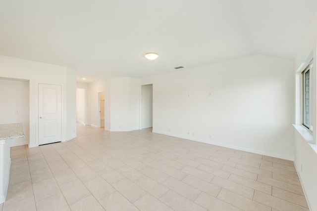 unfurnished room with lofted ceiling