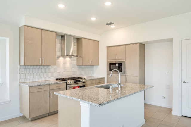 kitchen featuring sink, a kitchen island with sink, wall chimney range hood, and stainless steel appliances