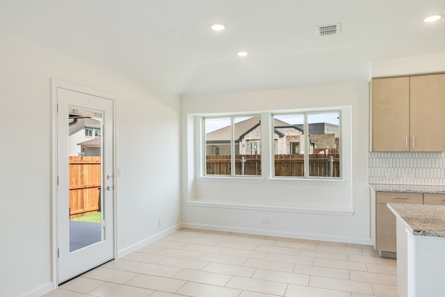 unfurnished dining area featuring a healthy amount of sunlight and light tile patterned floors