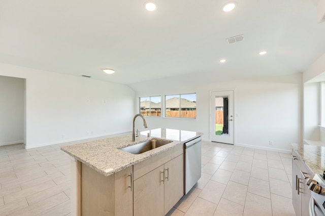 kitchen featuring an island with sink, light brown cabinetry, stainless steel appliances, sink, and light stone counters