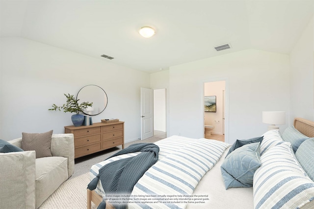 carpeted bedroom with ensuite bath and vaulted ceiling