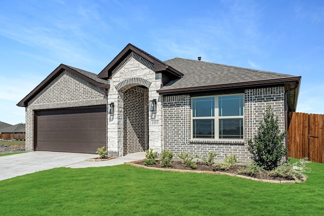 view of front of house featuring a garage and a front lawn