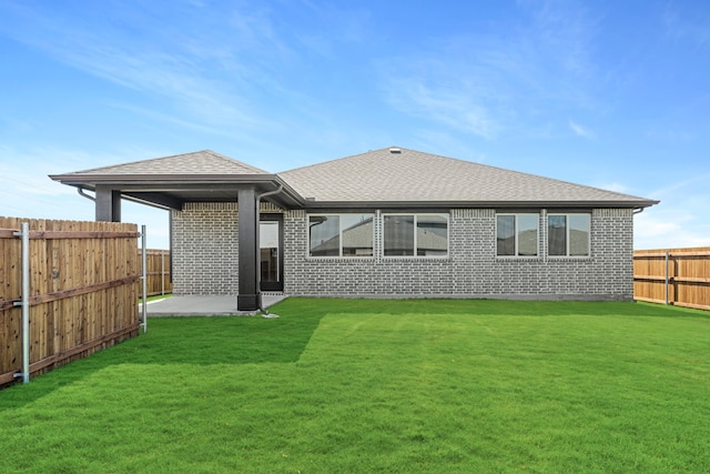 rear view of house with a yard and a patio