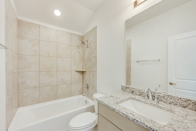 full bathroom featuring tiled shower / bath, vanity, vaulted ceiling, and toilet