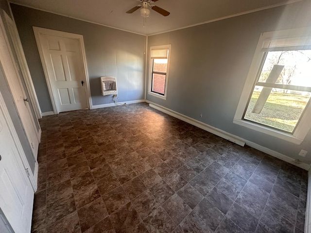 spare room with heating unit, crown molding, plenty of natural light, and ceiling fan