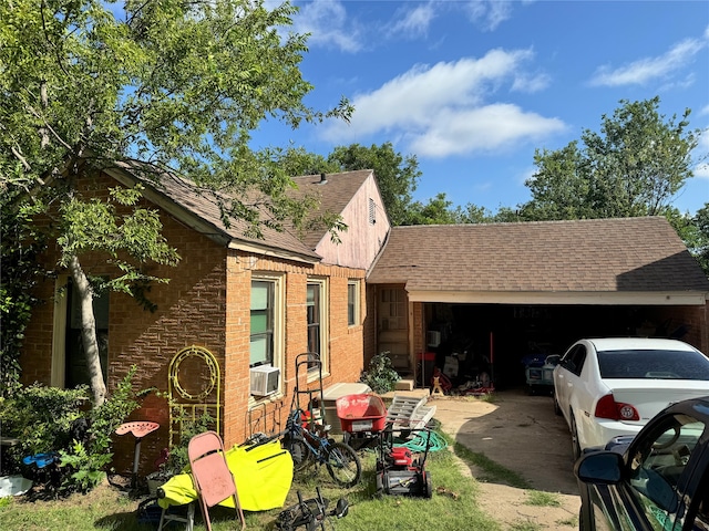 view of side of home featuring cooling unit and a garage