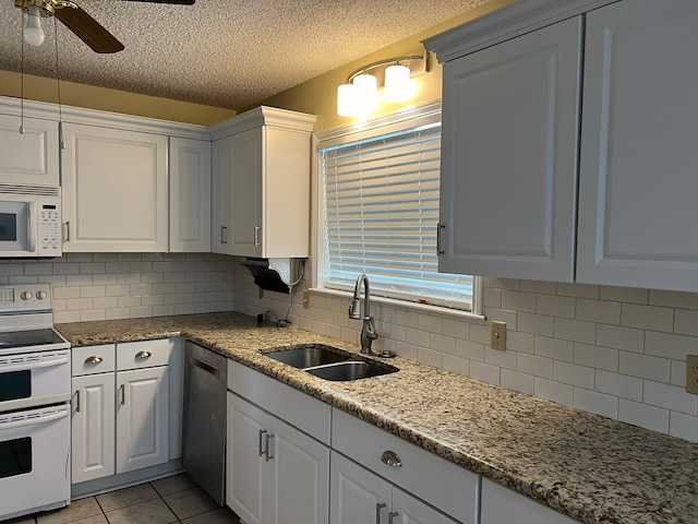 kitchen featuring white cabinetry, backsplash, white appliances, and ceiling fan