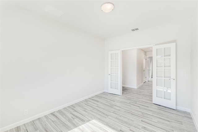 spare room with french doors and light hardwood / wood-style flooring