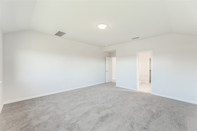 carpeted spare room with lofted ceiling