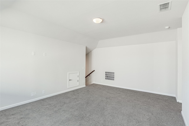 carpeted spare room with lofted ceiling