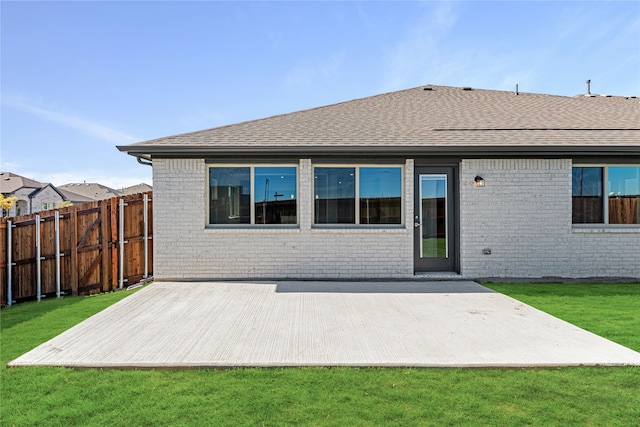 rear view of property featuring a patio area and a lawn