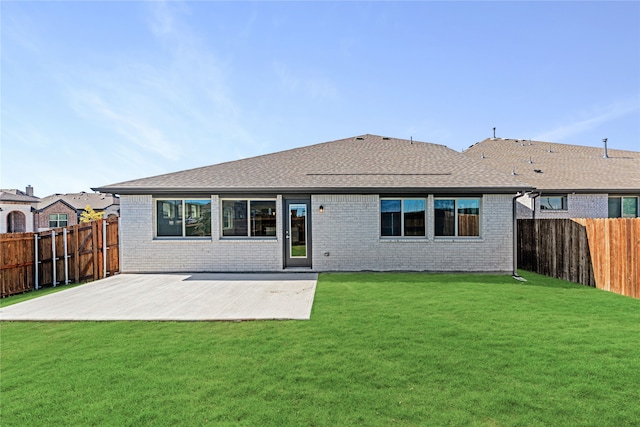 rear view of property with a lawn and a patio area