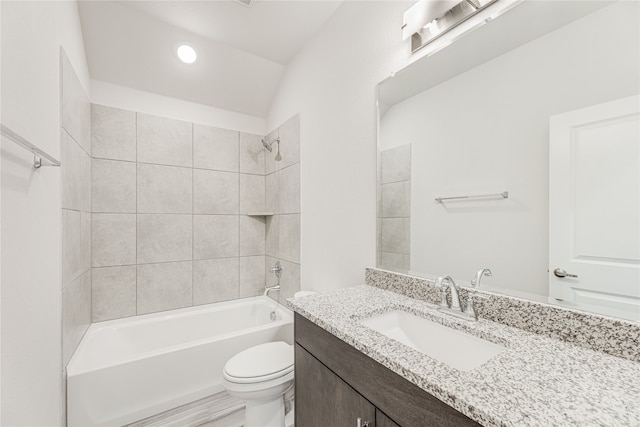 full bathroom featuring vanity, tiled shower / bath combo, hardwood / wood-style floors, toilet, and lofted ceiling