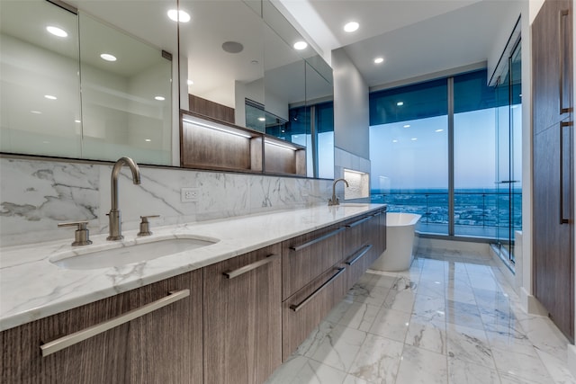 bathroom with tile patterned floors, a water view, decorative backsplash, dual vanity, and a bathtub