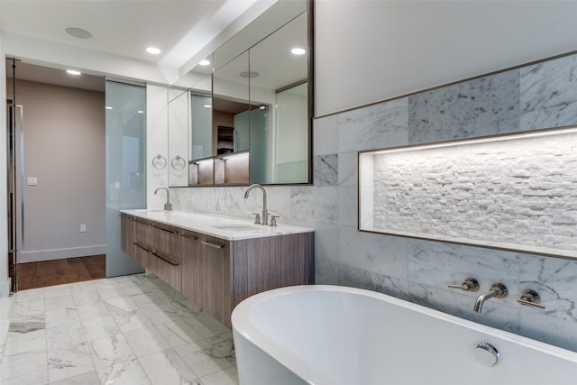 bathroom with a bath, double vanity, backsplash, tile walls, and hardwood / wood-style flooring