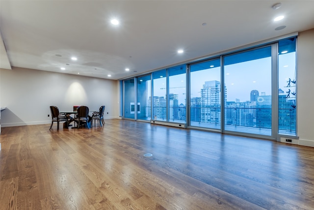 exercise room with floor to ceiling windows and wood-type flooring