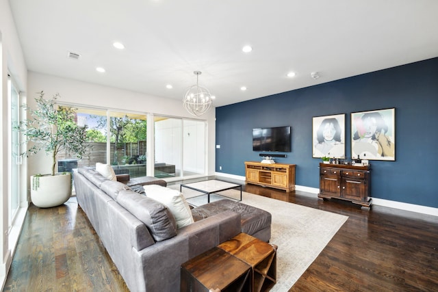 living room featuring an inviting chandelier and dark hardwood / wood-style floors