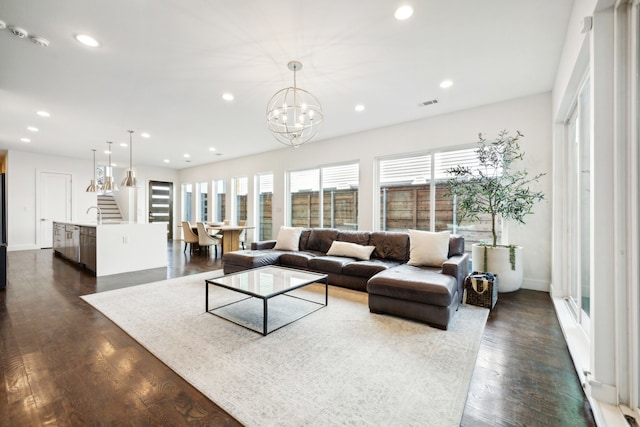 living room with dark hardwood / wood-style floors, a notable chandelier, and sink