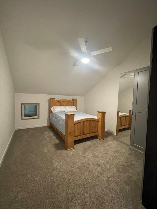 unfurnished bedroom featuring ceiling fan, lofted ceiling, and dark carpet