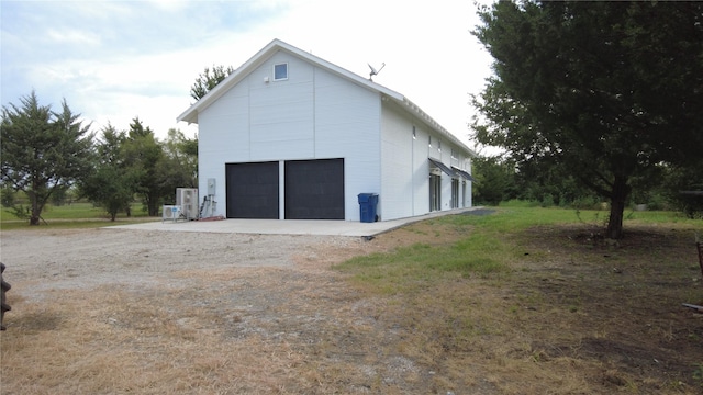 view of side of property featuring a garage and an outbuilding