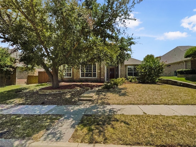 view of property hidden behind natural elements with a front lawn