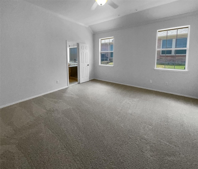 empty room with vaulted ceiling, carpet floors, and ceiling fan