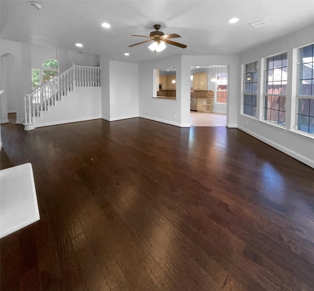 unfurnished living room with ceiling fan and dark hardwood / wood-style floors