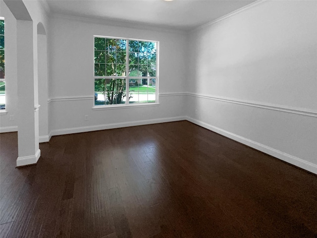 spare room with ornamental molding and dark hardwood / wood-style flooring