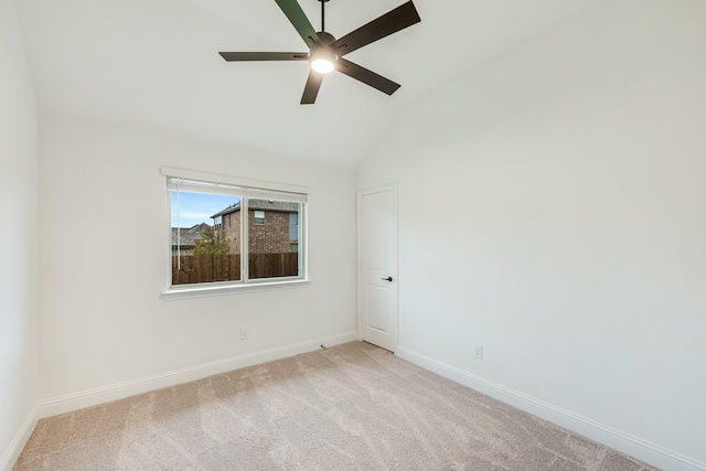 carpeted spare room with ceiling fan and vaulted ceiling