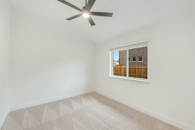 carpeted spare room featuring vaulted ceiling and ceiling fan