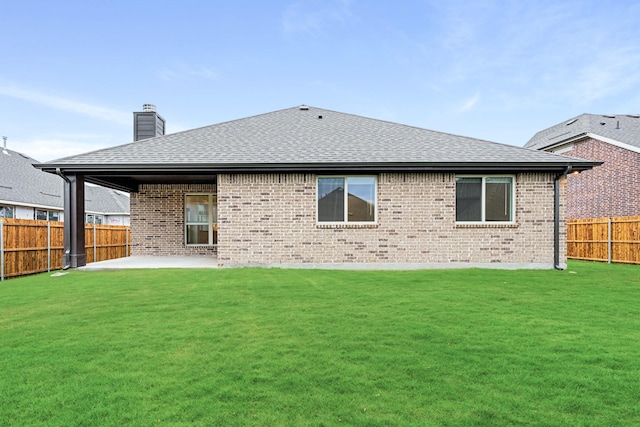 rear view of property with a yard and a patio