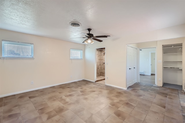 empty room featuring ceiling fan and a textured ceiling