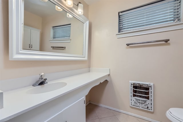 bathroom with tile patterned flooring, vanity, heating unit, and toilet