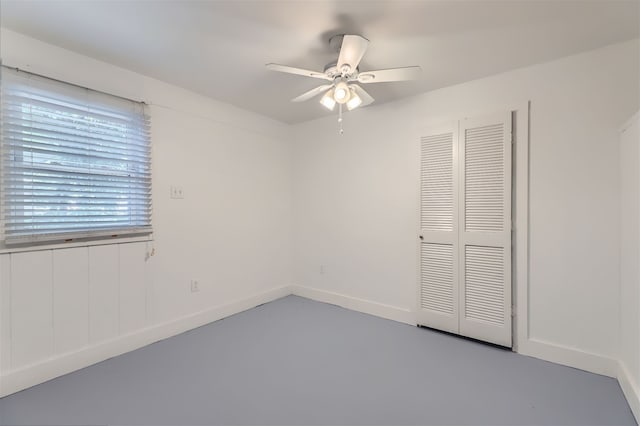 unfurnished bedroom featuring concrete floors, ceiling fan, and a closet