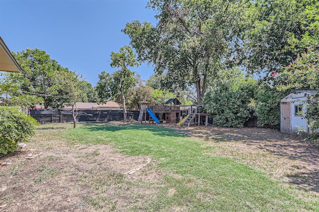 view of yard featuring a playground and a storage unit