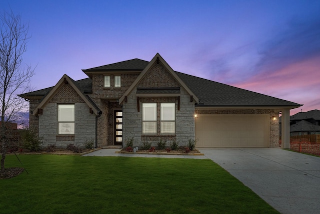 view of front of home with a garage and a lawn