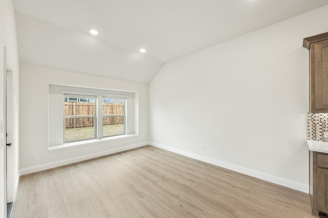 unfurnished dining area with lofted ceiling and light hardwood / wood-style flooring