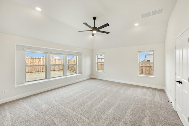 carpeted empty room featuring lofted ceiling, a wealth of natural light, and ceiling fan