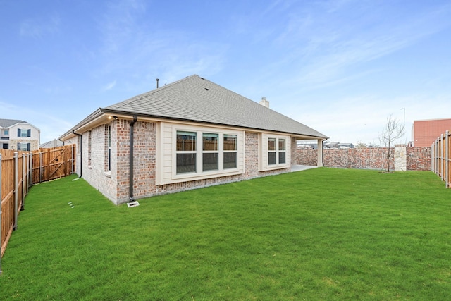 rear view of property featuring a lawn