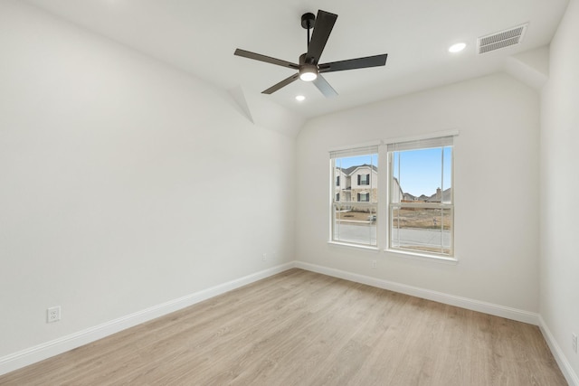 empty room with vaulted ceiling, ceiling fan, and light hardwood / wood-style flooring