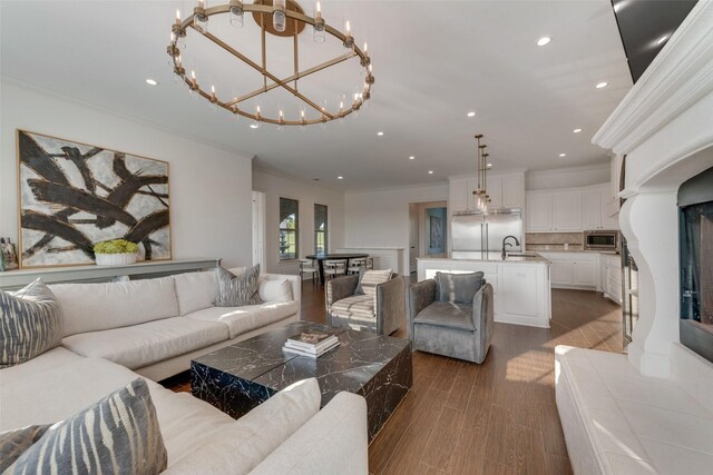 living room featuring recessed lighting, ornamental molding, dark wood-style floors, and a chandelier
