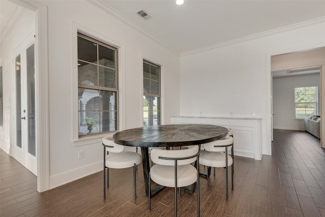 dining room with ornamental molding and dark hardwood / wood-style flooring