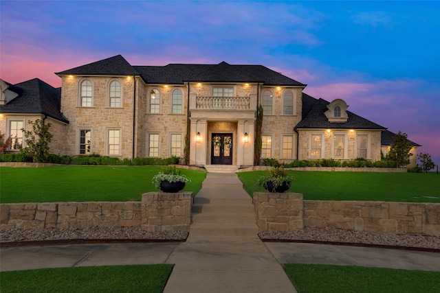 french country style house with a yard and a balcony