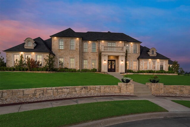 view of front of home with french doors, a yard, and stone siding