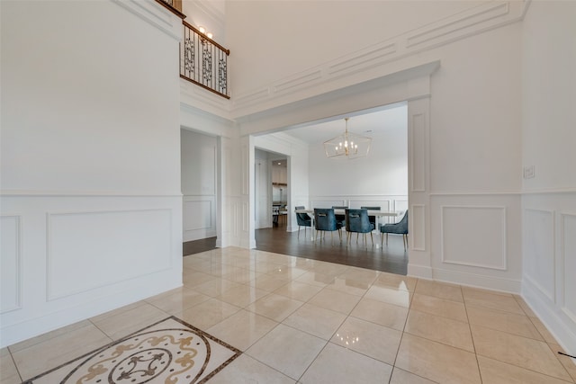 interior space with an inviting chandelier, crown molding, and tile patterned floors