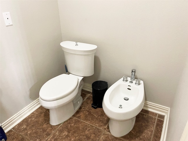 bathroom with tile patterned flooring, toilet, and a bidet