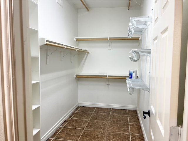 spacious closet featuring dark tile patterned flooring